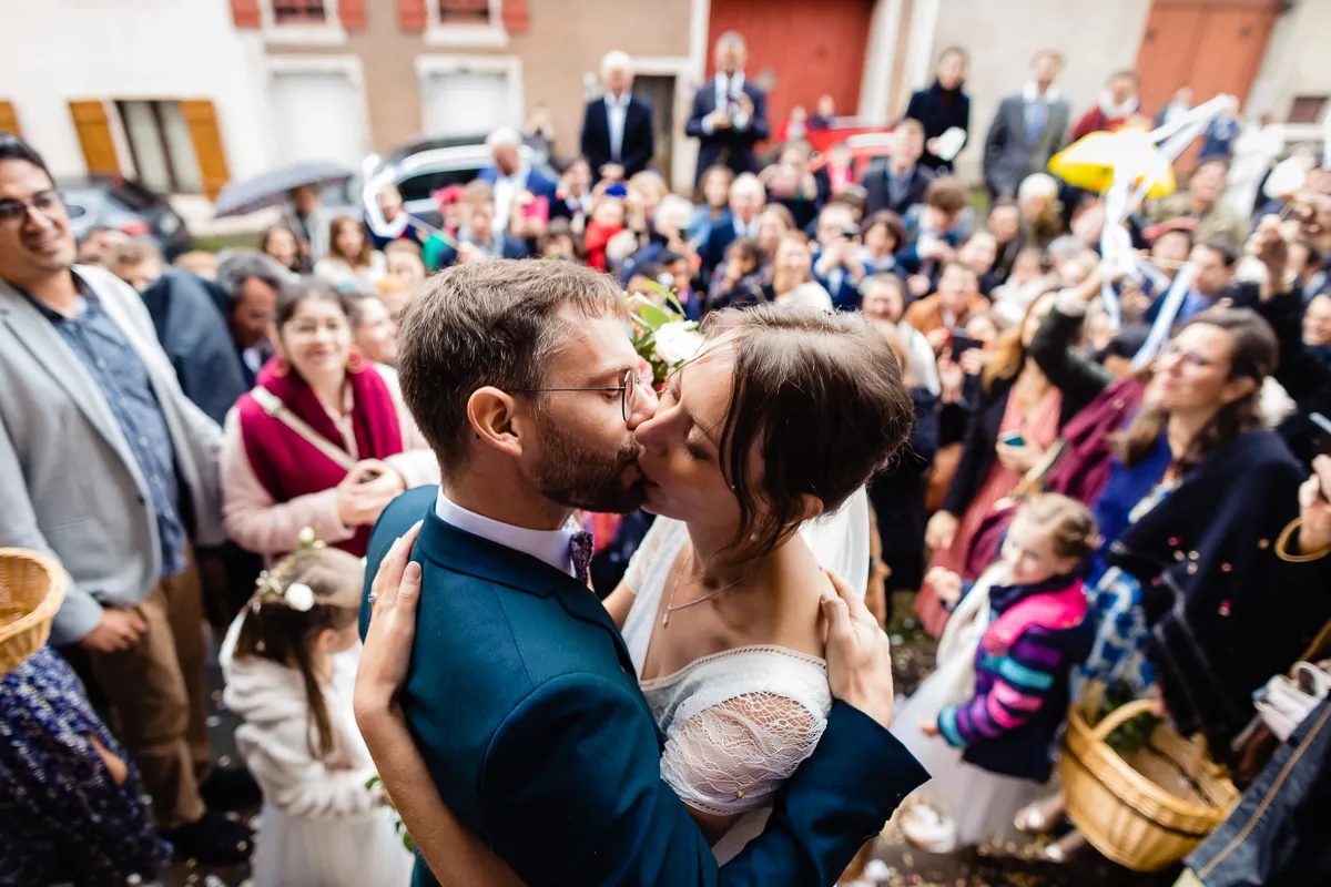 Mariés s'embrassant à la sortie de l'église.